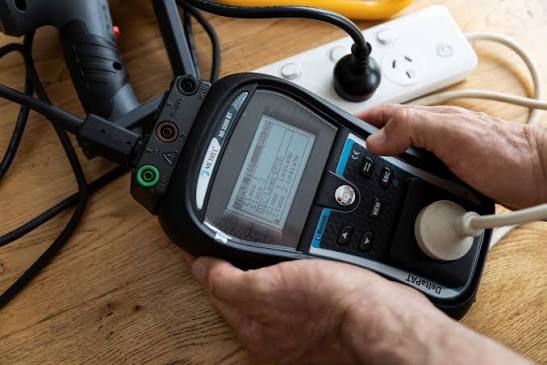 Technician performing portable appliance testing on equipment in Adelaide